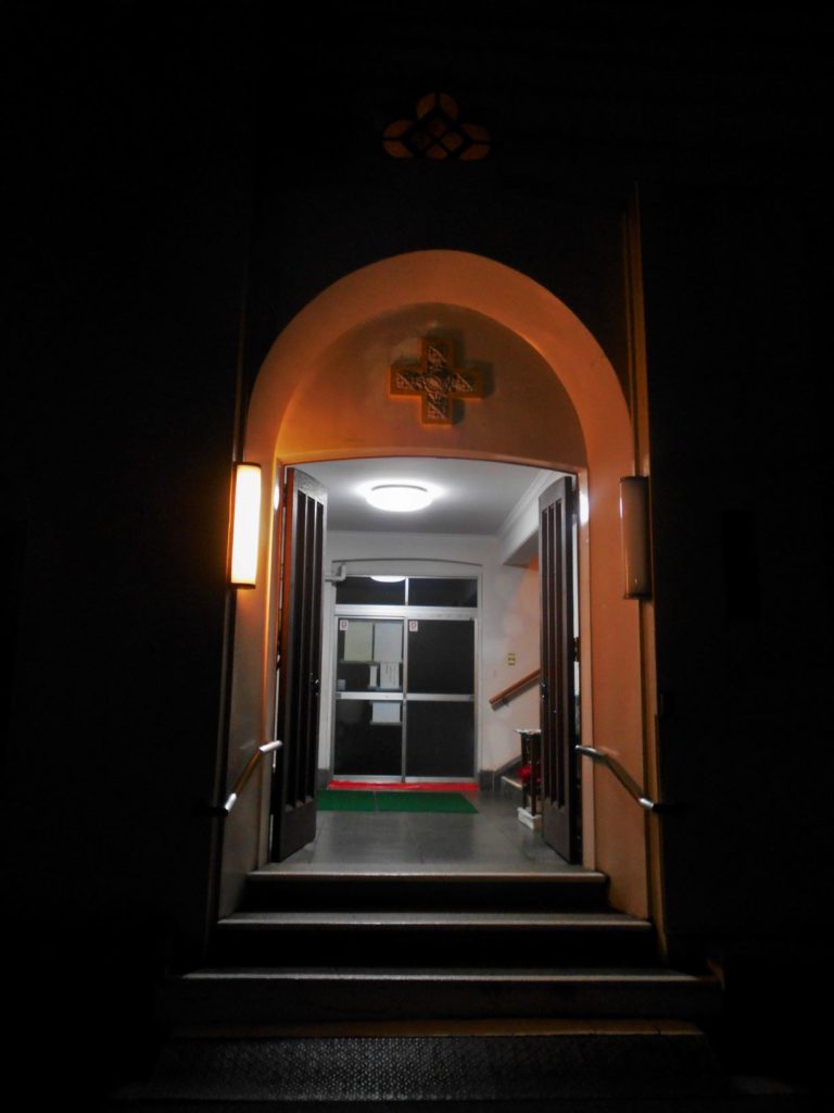 灯りのともる教会の入り口の画像.
