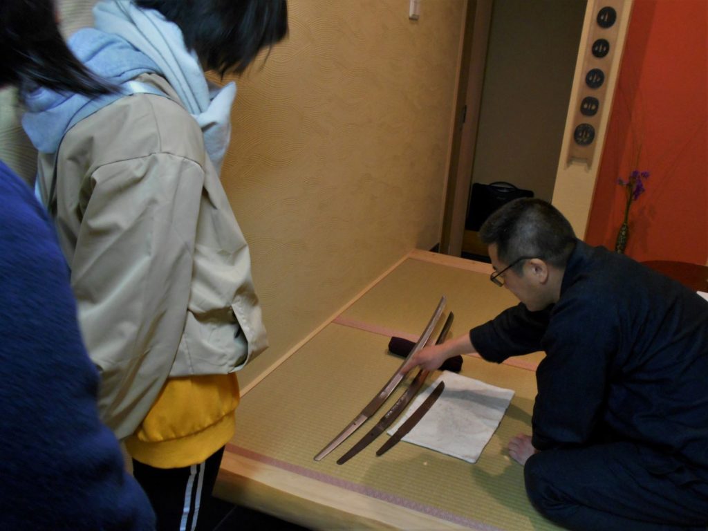 三本の日本刀を観察する画像。
