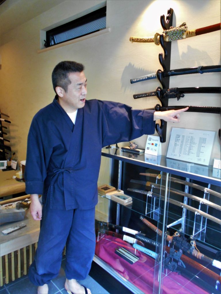 工房内の日本刀を使って刀の魅力を教えてくれる長岡先生の画像。