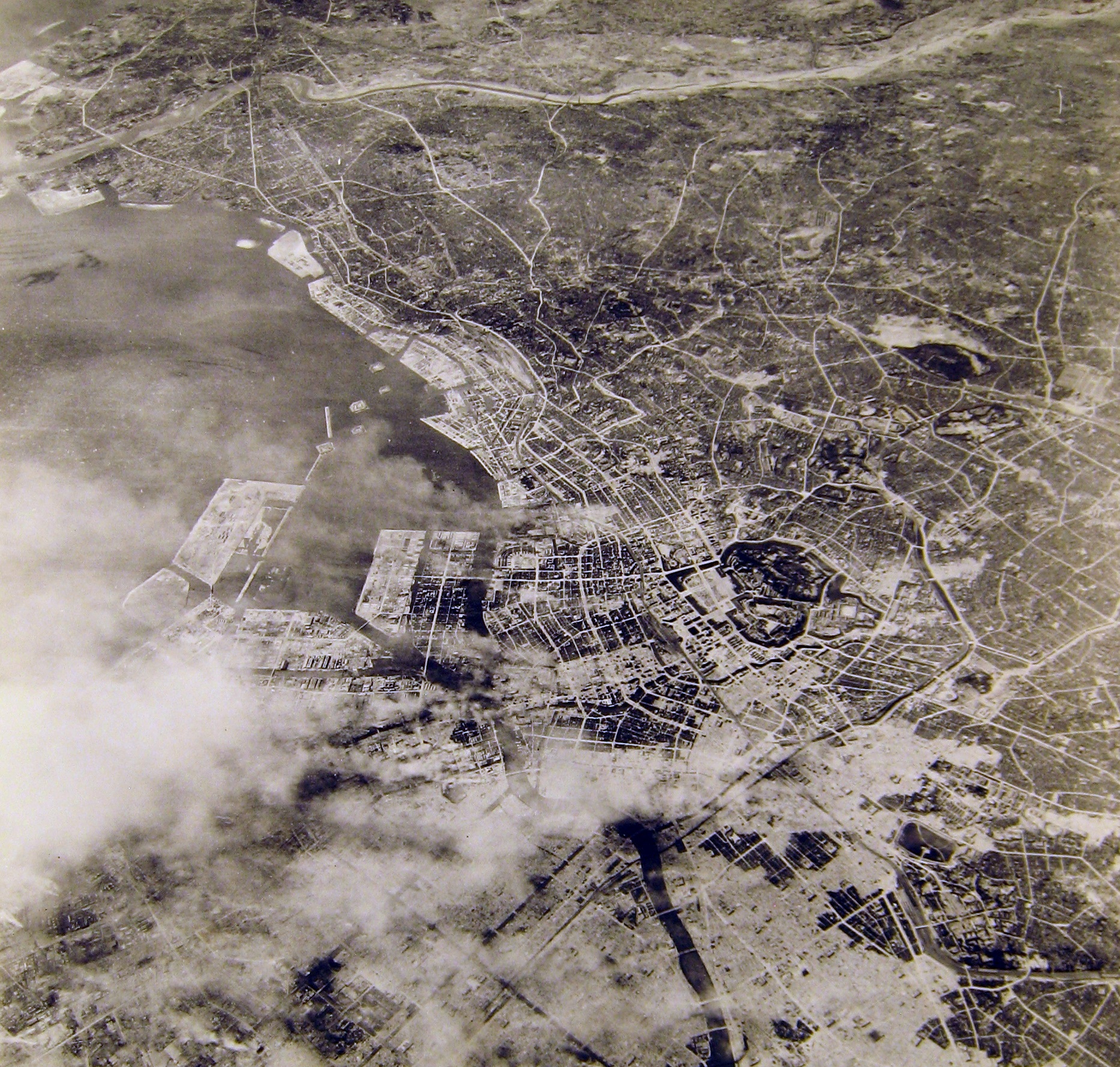 空襲で炎上する東京（USAAF_photo_of_Tokyo_after_the_10_March_air_raid、Wikipediaより20210807ダウンロード）の画像。